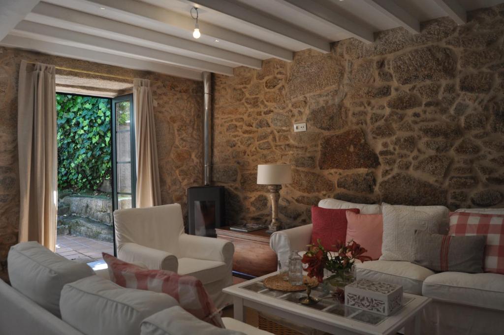 una sala de estar con sofás y una pared de piedra. en Casa tía Amparo, en Portosín