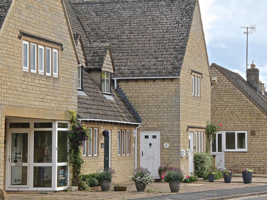 a group of houses with plants in front of them at Kate's Cottage in Bourton on the Water