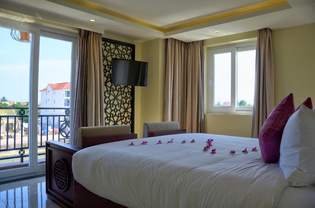 Postel nebo postele na pokoji v ubytování River Suites Hoi An