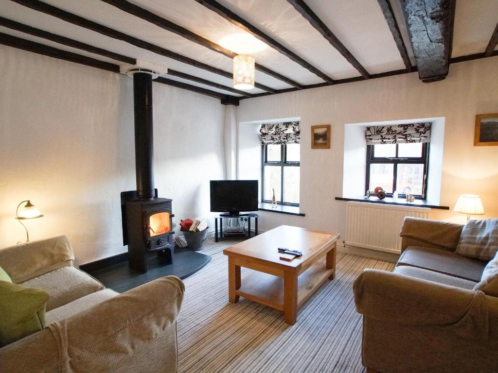 a living room with a wood stove in a room at Laurel Cottage in Ulverston