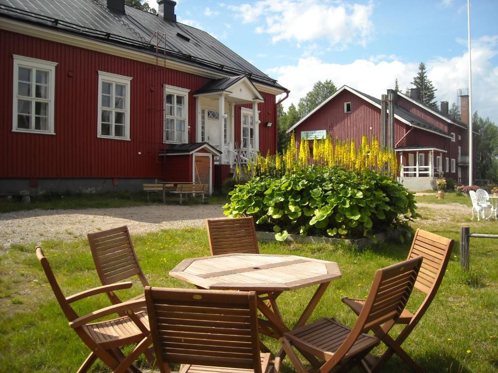 a wooden table and chairs in the yard of a house at Aneen Loma Vacation and Cottages in Anetjärvi