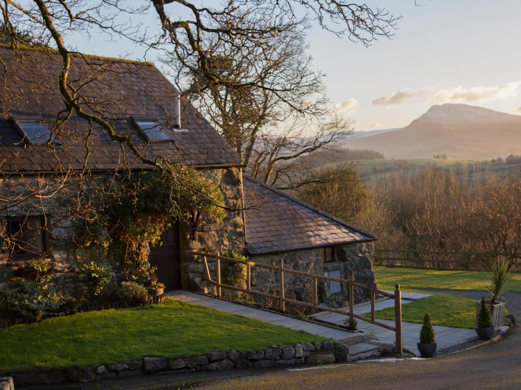 an old stone house with mountains in the background at Cyffdy Cottage - Tegid in Bala