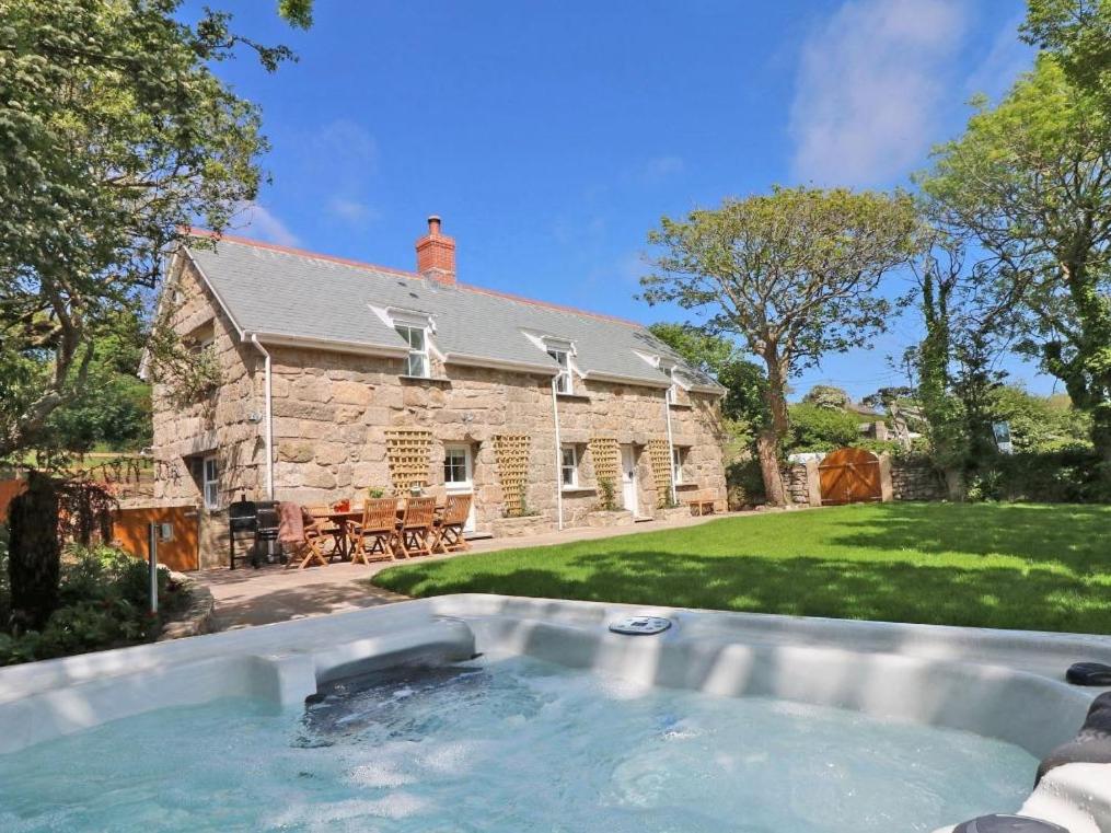 a stone house with a swimming pool in the yard at The Old Forge, St Just in St. Just