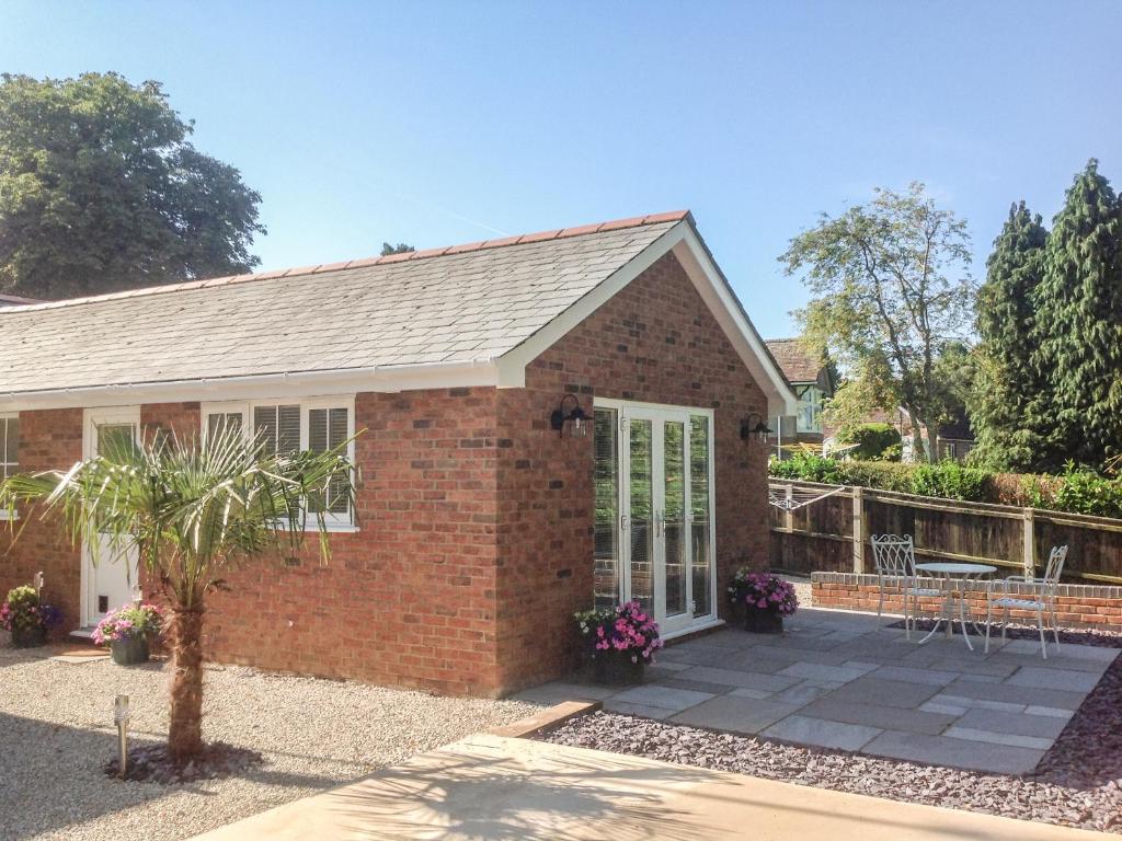 a brick house with a patio at The Hideaway in Verwood