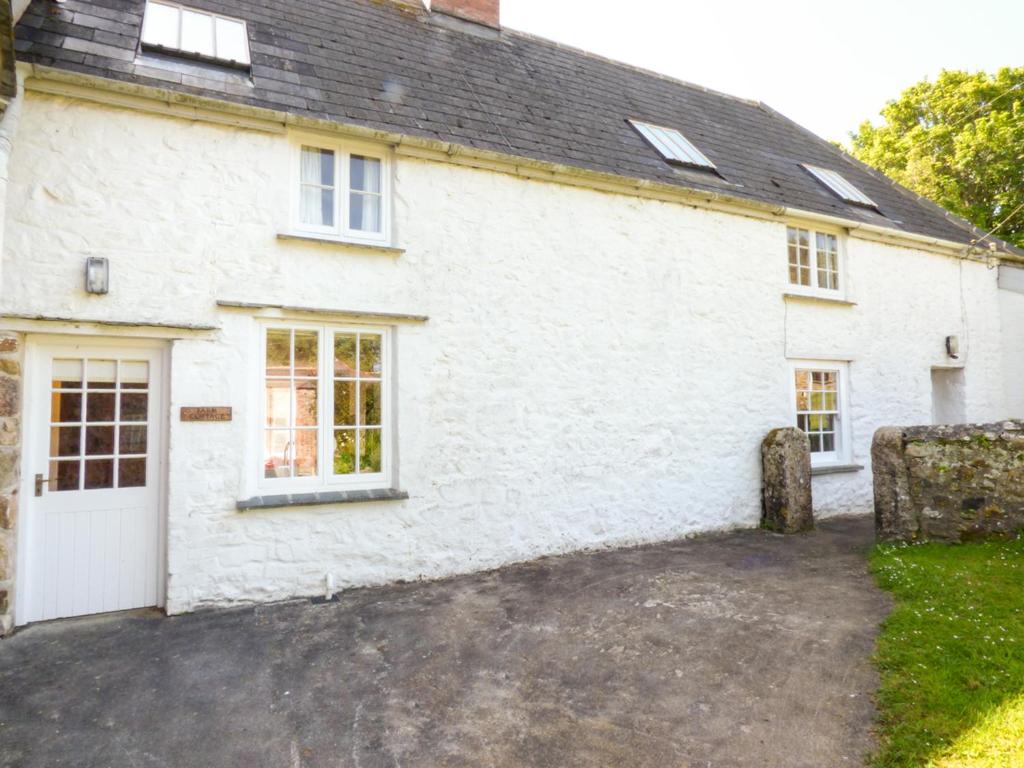 una casa blanca con una entrada delante de ella en Farm Cottage en Saint Erth