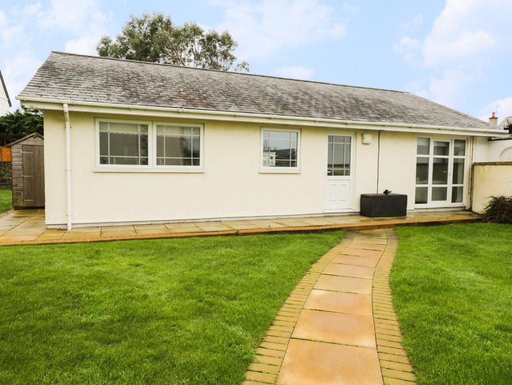 a house with a green lawn in front of it at The Bungalow in Pwllheli