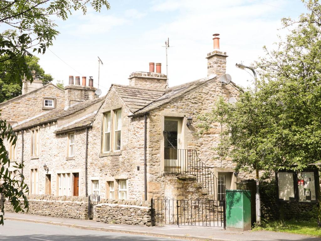 an old stone house on the corner of a street at Orchard Cottage in Lothersdale