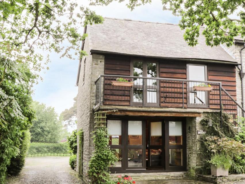 Cette maison dispose de grandes fenêtres et d'un balcon. dans l'établissement The Granary, à Bucknell