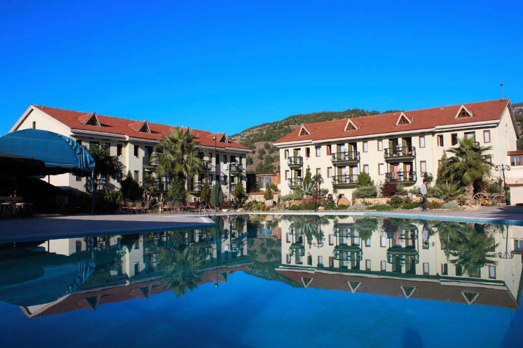 un hôtel avec une piscine d'eau en face dans l'établissement Halıcı Hotel Resort & SPA, à Pamukkale