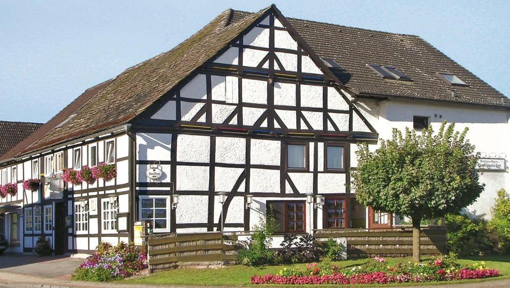 a black and white building with flowers in front of it at Landgasthaus Hoffmeister in Hehlen