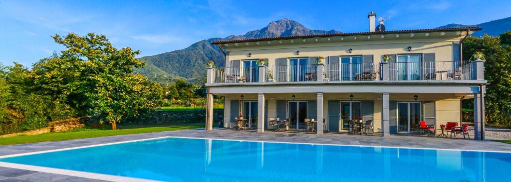 a house with a swimming pool in front of a house at Foresteria Villa Margherita in Colico