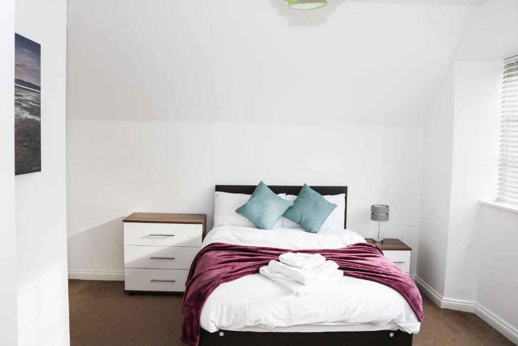 1 dormitorio con paredes blancas y 1 cama con almohadas azules en Parks Nest 6 en Hull
