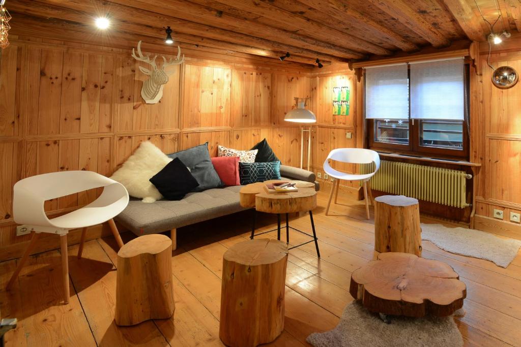 a living room with a couch and wooden walls at KAYSERSBERG city center - House "AUX 7 FORGERONS" - in Kaysersberg