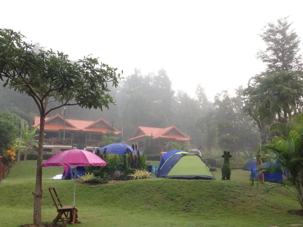 a group of tents in a field in the rain at Sangsawang Resort in Mae Hong Son