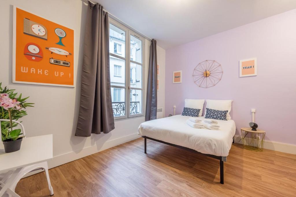 una piccola camera con letto e finestra di Apartments WS Hôtel de Ville - Musée Pompidou a Parigi