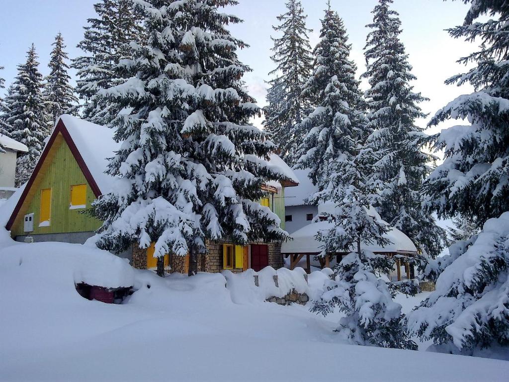eine Hütte im Schnee mit schneebedeckten Bäumen in der Unterkunft Apartmani Smreka Vlašić in Vlasic