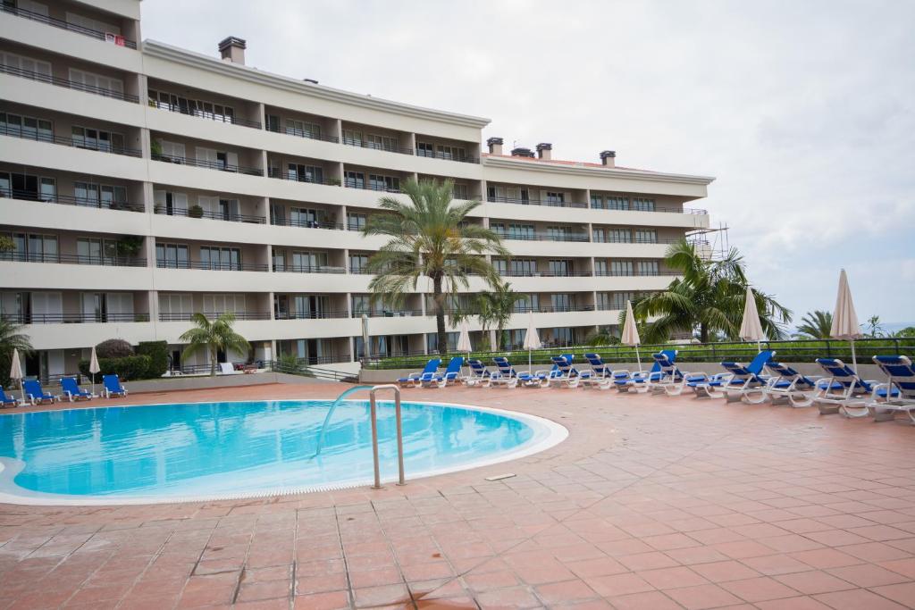 un hotel con piscina, sillas y un edificio en M Palace II, en Funchal