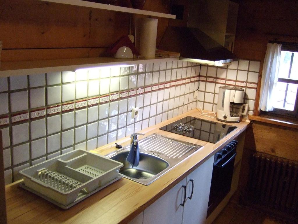 a kitchen counter with a sink and a stove at Gästehaus Banik in Seebruck