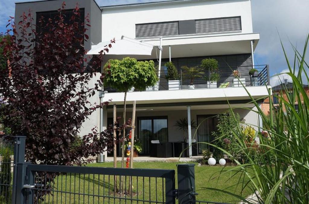 une maison blanche avec une clôture devant elle dans l'établissement Ferienwohnung Familie Nachtmann, à Beilngries