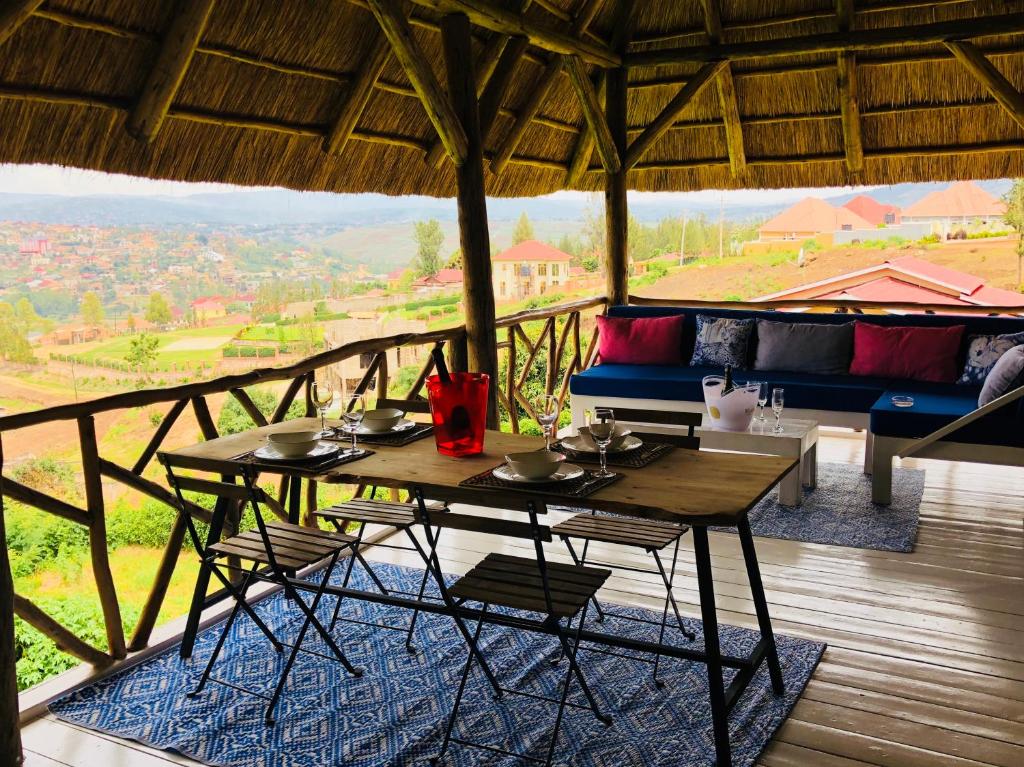 een houten tafel en stoelen op een balkon met uitzicht bij Pili Pili Boutique Hotel in Kigali