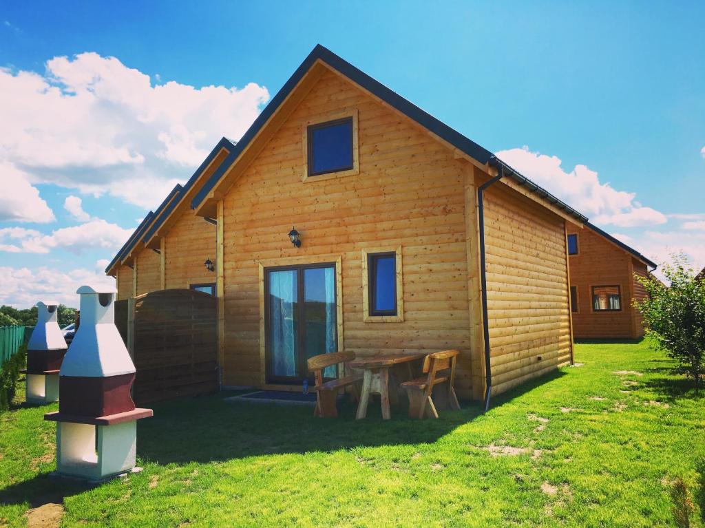 una pequeña casa de madera con una mesa y una mesa en Ferienhäuser Eurobaltyk, en Rewal