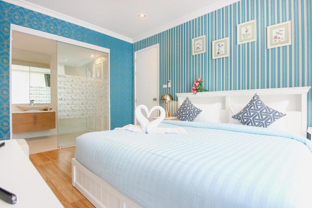 une chambre avec un grand lit blanc et une salle de bain dans l'établissement My Resort Hua Hin B111, à Hua Hin