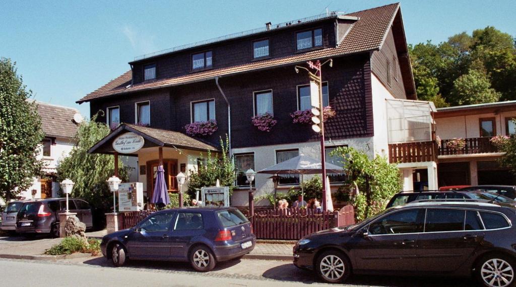 dos coches estacionados frente a un edificio en Gasthof Zur Linde, en Diemelsee