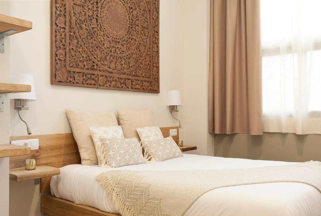 ein Schlafzimmer mit einem Bett mit einem Bild an der Wand in der Unterkunft Hotel Radha in Hospitalet de Llobregat