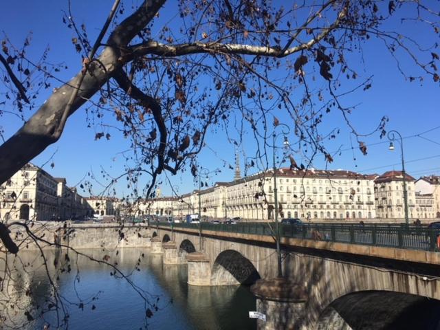 un ponte su un fiume in una città con edifici di Vittorio 21 a Torino