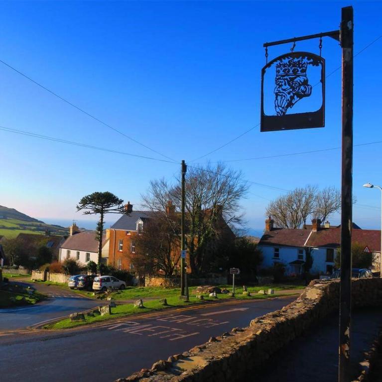 a street sign on a pole next to a street at King's Head Inn in Llangennith