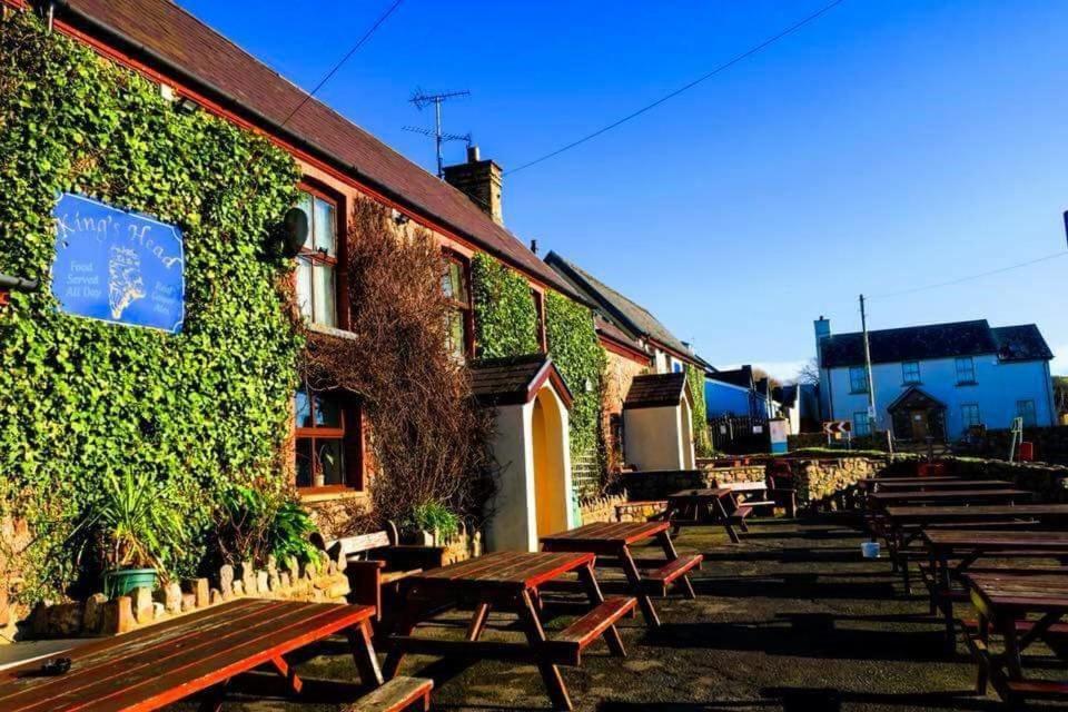 a group of benches sitting outside of a building at King's Head Inn in Llangennith