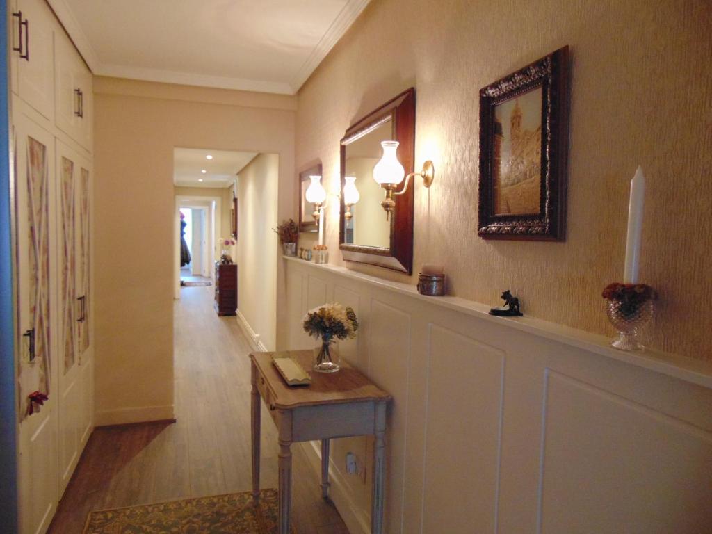- un couloir avec une table fleurie dans l'établissement Apartamento Riazor Coruña, à La Corogne