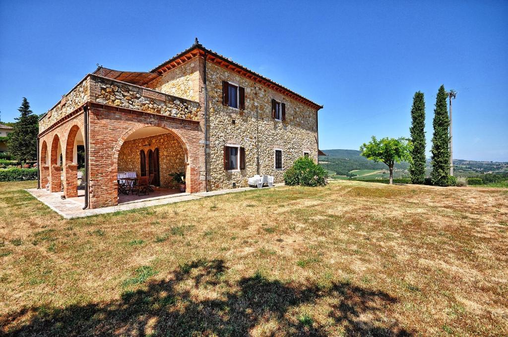 duży kamienny dom na trawniku w obiekcie Vittoriana near San Gimignano by PosarelliVillas w mieście San Gimignano