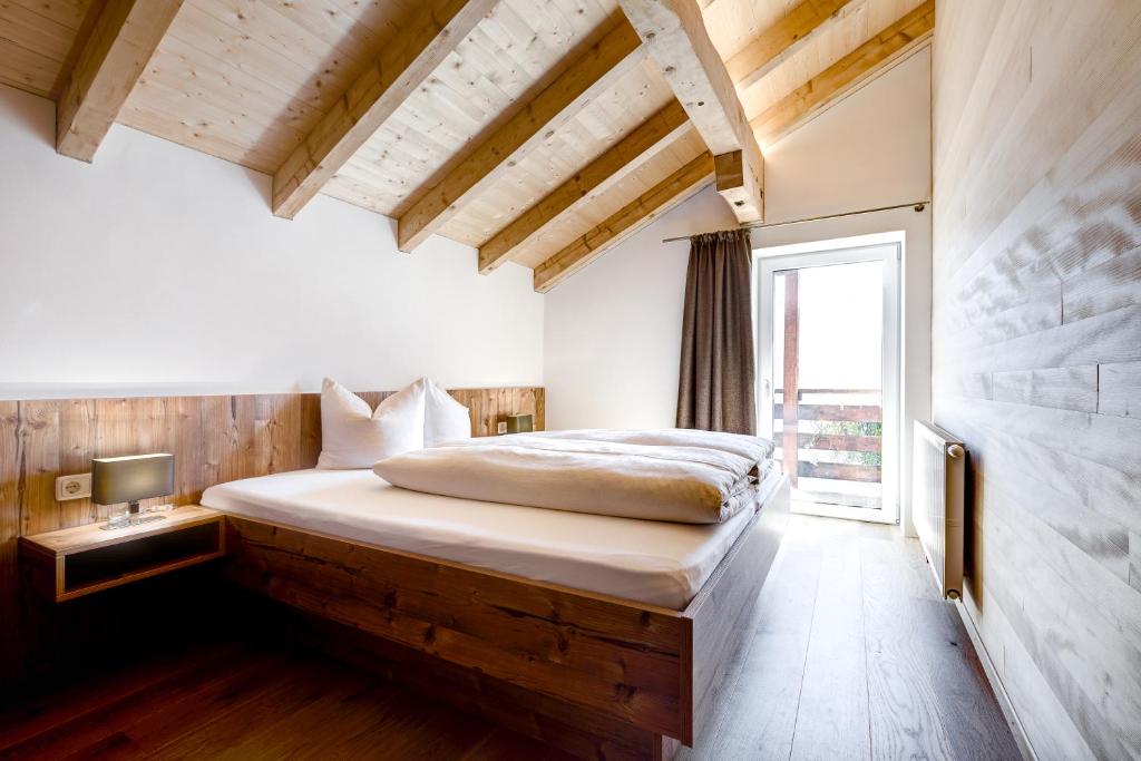 a bedroom with a bed in a room with a window at Familienbauernhof Burtscher in Fontanella