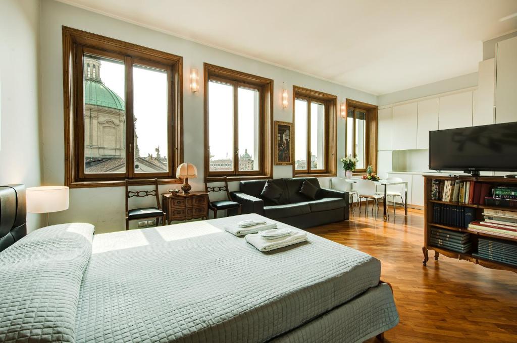 ミラノにあるBnButler - Duomo Apartment - Galleria Unioneのベッド、ソファ、テレビが備わる客室です。