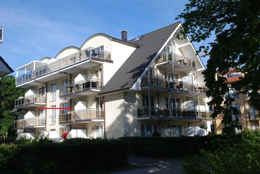バーベにあるFerienwohnung-Ruegenzauberの黒屋根の白い大きなアパートメントビル