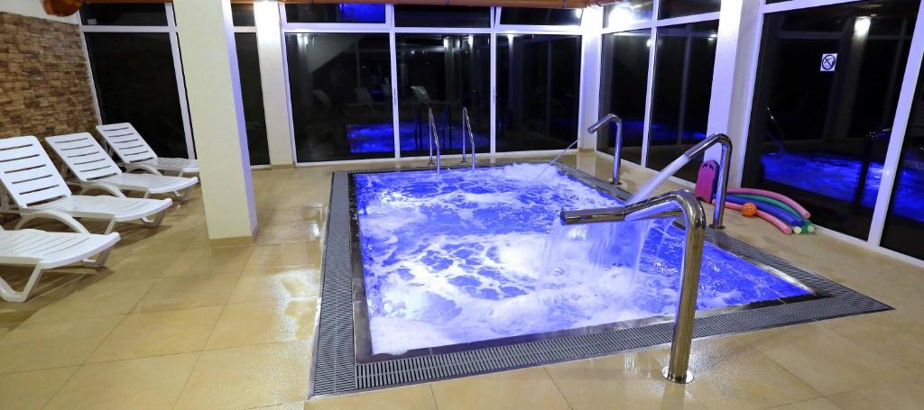a hot tub in the middle of a room with chairs at Centrum Wypoczynku Victoria Spa in Grzybowo