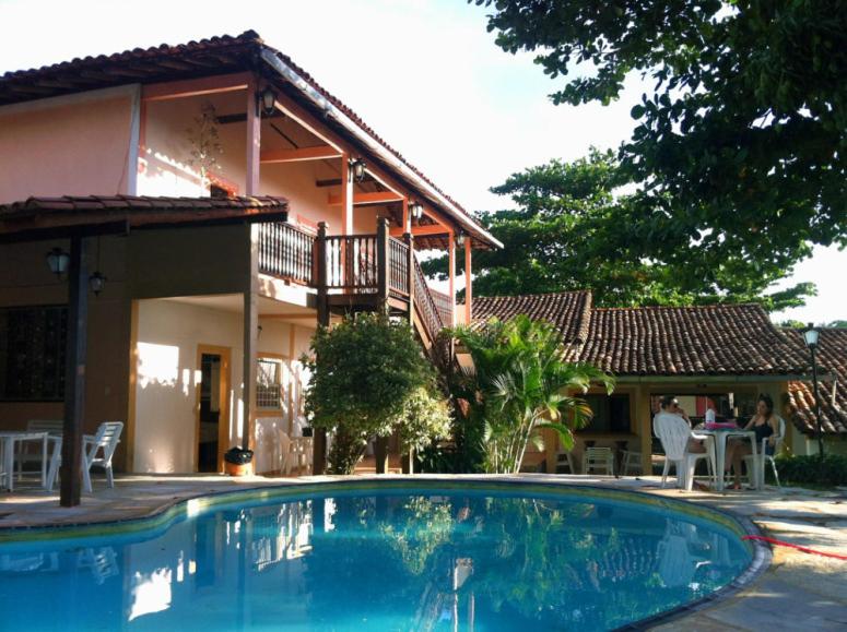 a house with a swimming pool in front of a house at Pousada Pouso do Frade in Pirenópolis