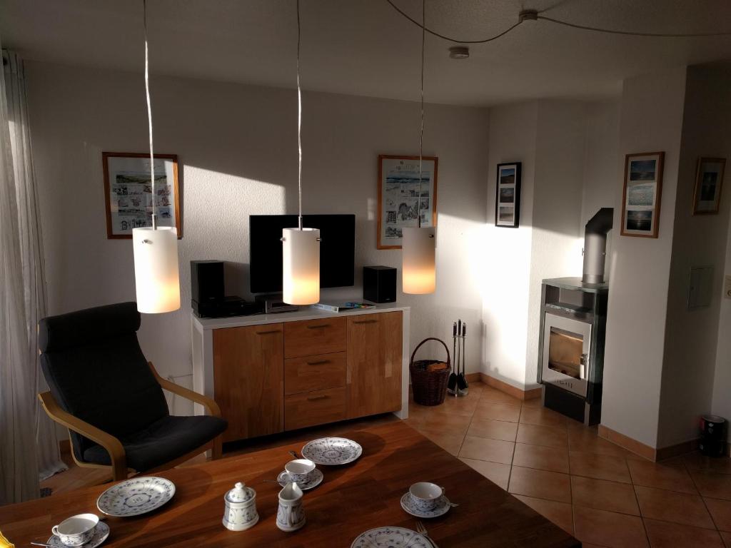 a living room with a table and a television at Whg Suedblick auf Föhr in Goting