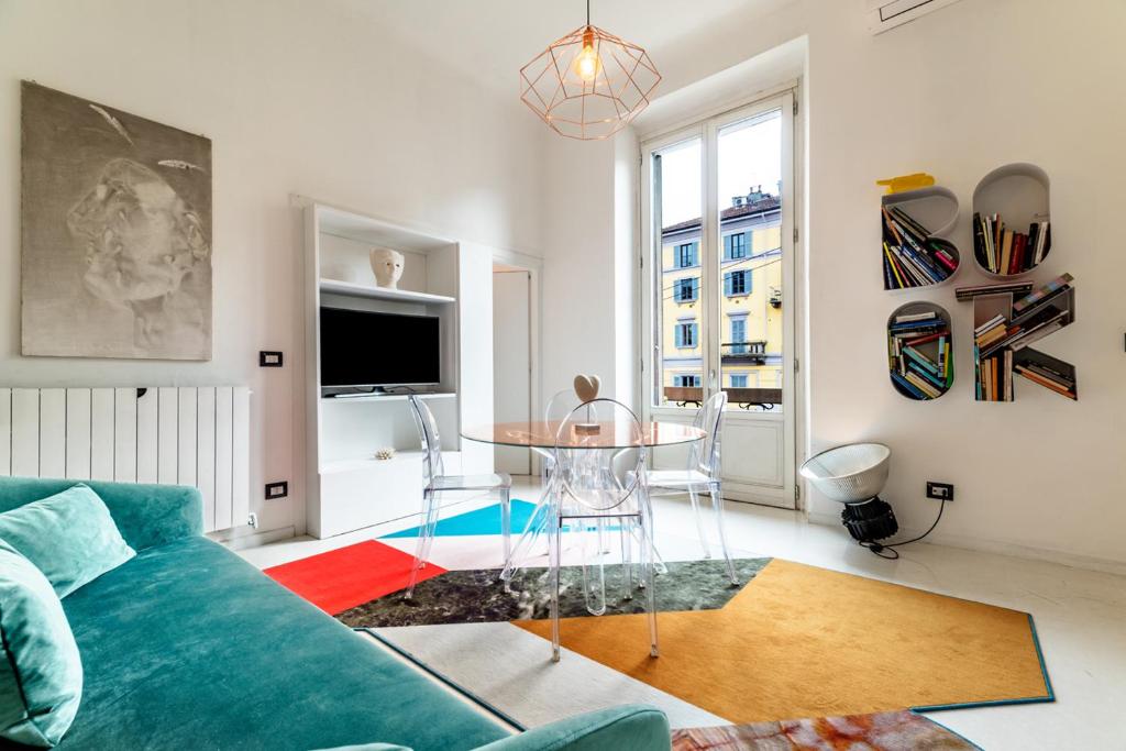 salon z niebieską kanapą i stołem w obiekcie Apartment 3BR 2BT - Naviglio w Mediolanie