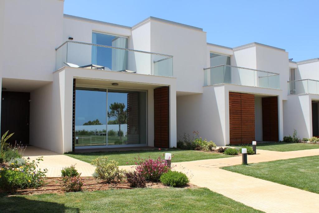une maison blanche avec une pelouse devant elle dans l'établissement Seasagres - Design Villas, à Sagres