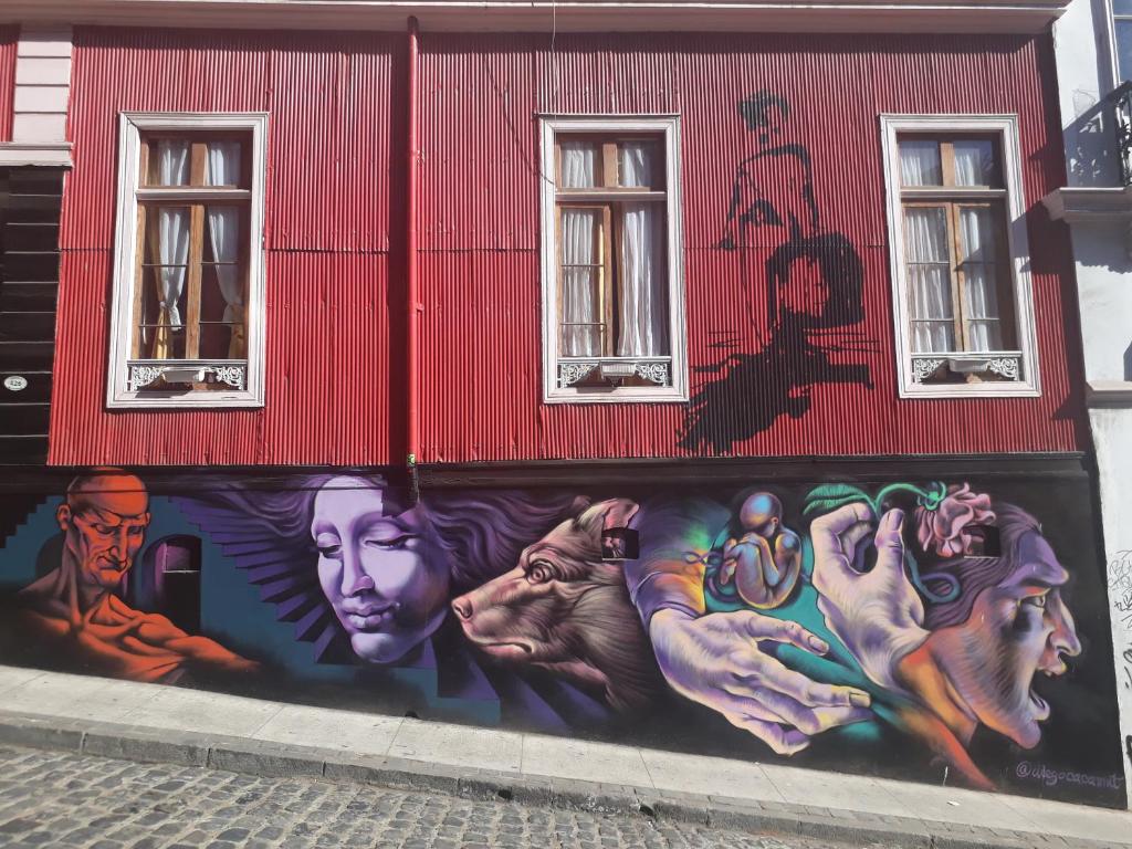 un mural en el lateral de un edificio rojo en Maki Suites ex Hotel Da Vinci, en Valparaíso