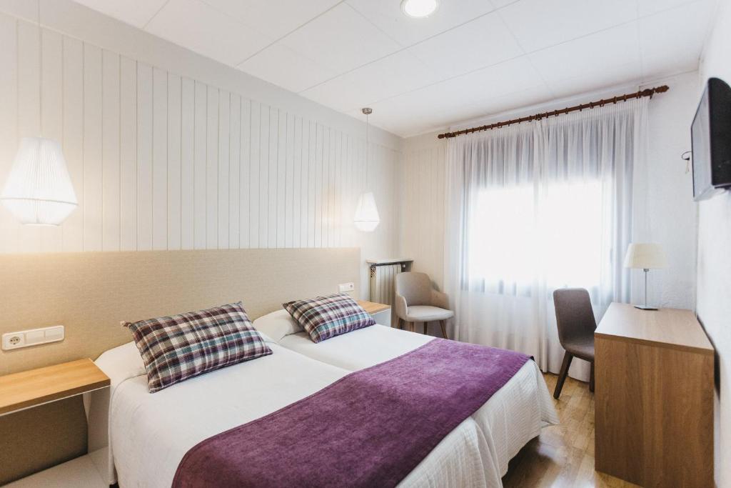 una camera d'albergo con un grande letto e una finestra di Hotel Catalunya Ribes de Freser a Ribes de Freser