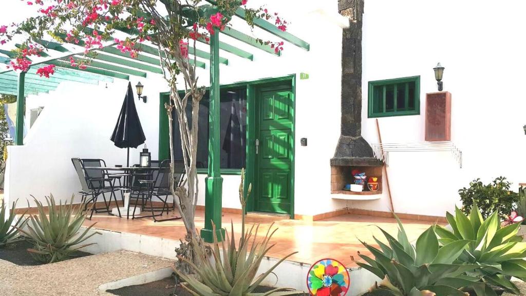 a house with a green door and a table and chairs at Bungalow King in Puerto del Carmen