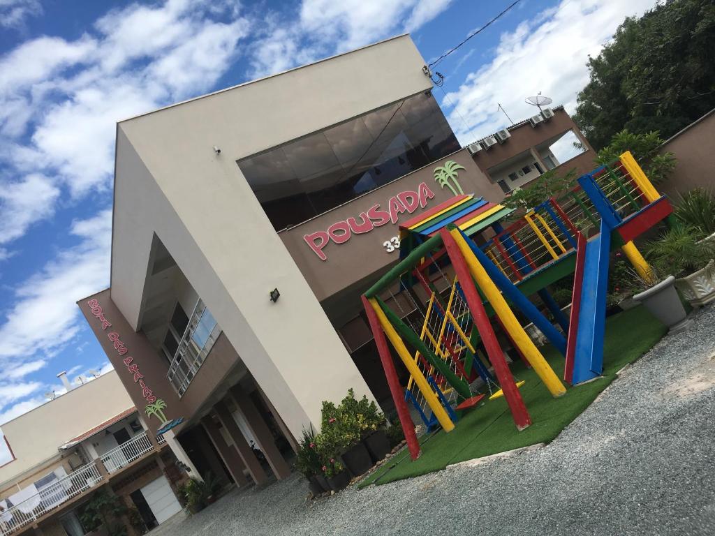 um edifício com um parque infantil em frente a uma loja em Pousada Rota das Praias em Penha