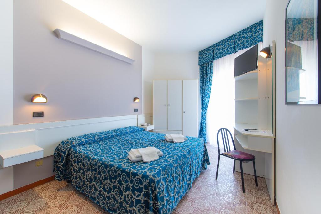 Hotel 2000 في ريميني: غرفة نوم بسرير وكرسي ونافذة