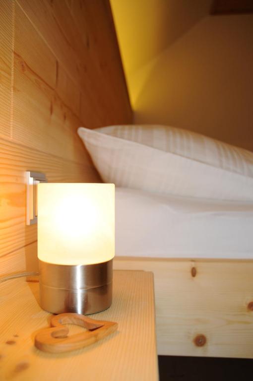 eine Lampe auf einem Tisch neben einem Bett in der Unterkunft Gästehaus Brugger in Hermagor