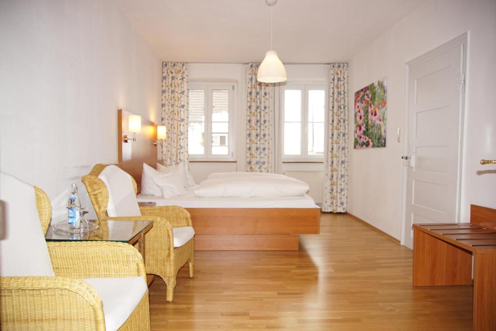 a hotel room with a bed and a table and chairs at Hotel-Restaurant Roter Ochsen in Lauchheim
