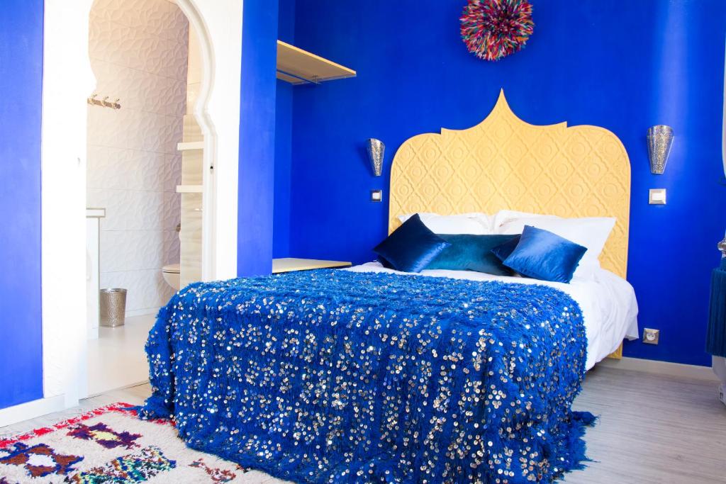 a bedroom with blue walls and a bed with a blue bedspread at Riad SPA &quot;Les Portes de l&#39;Orient&quot; TOURS in Tours