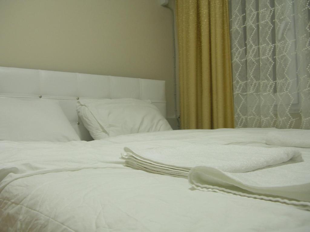 イスタンブールにあるトゥルコ アパートメンツのベッドルーム1室(白いシーツが備わるベッド2台付)